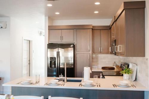 a kitchen with wooden cabinets and a counter with plates at Stunning Twnhme by Golf*LasPalmas Resort poolpass* Central St. George in St. George