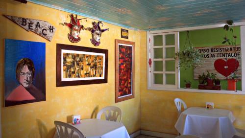 a dining room with two tables and a window at Pousada Mare Blue in Búzios