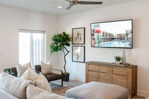 a living room with a couch and a tv on the wall at 20| Vue at Green Valley with Community Pool in St. George