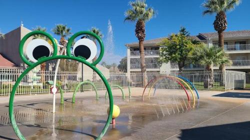 a water fountain in a park with palm trees at 20| Vue at Green Valley with Community Pool in St. George