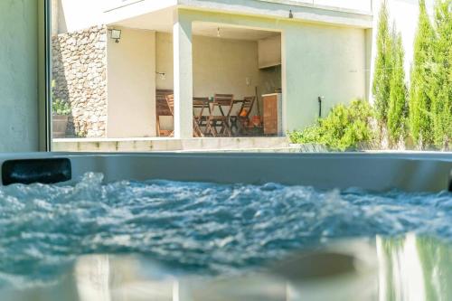 a pool of water in front of a house at Casa do Cabo Ponte de Lima - Jacuzzi and Pool in Ponte de Lima