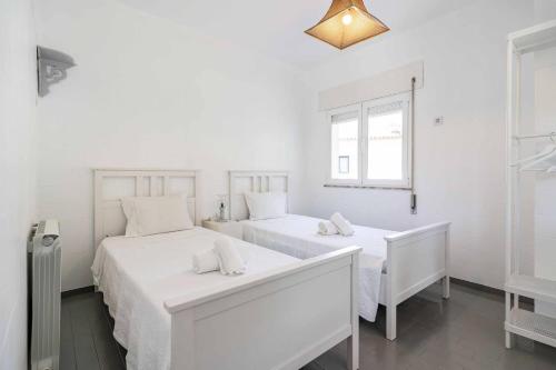 two white beds in a white room with a window at Casa Das Fontes Ponte De Lima - Jaccuzzi And Pool in Ponte de Lima