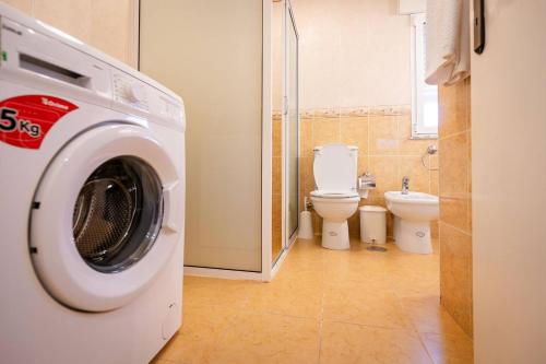 a washing machine in a bathroom with a toilet at Casa Das Fontes Ponte De Lima - Jaccuzzi And Pool in Ponte de Lima