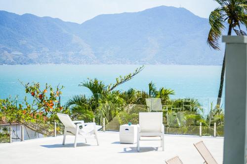 um pátio com vista para o oceano e para as montanhas em VELINN Pousada Casa da Imperatriz em Ilhabela