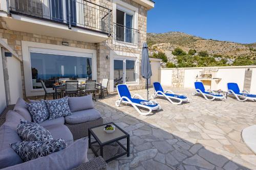 a patio with a couch and chairs and a table at Luxury Villa Layla with private pool near Dubrovnik in Ivanica