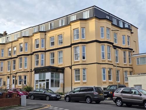 a yellow building with cars parked in front of it at Rivelyn Hotel Bar & Restaurant in Scarborough