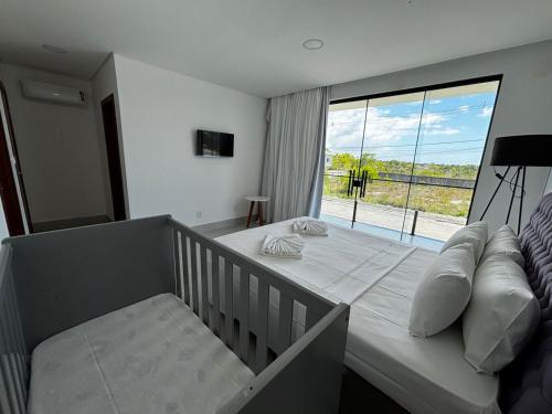 een slaapkamer met een bed en een groot raam bij Morada de Gaudi in Porto Seguro