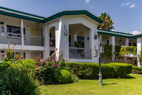 ein großes weißes Haus mit einem Hof in der Unterkunft Quinta Dorada Hotel & Suites in Saltillo