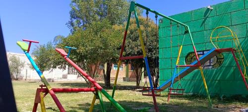 a playground with different colored play equipment in a park at Hotel y Cabañas El Taxho 