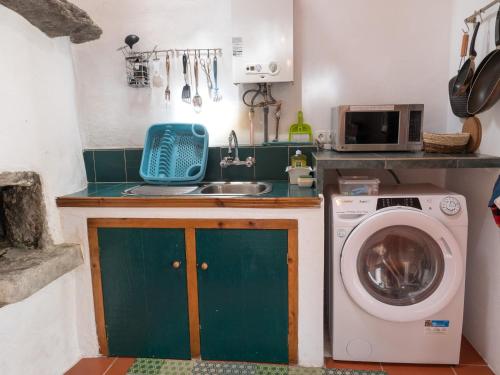a kitchen with a sink and a washing machine at Casita - your home in Flores in Lajes das Flores