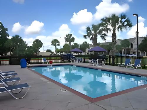 una gran piscina con sillas y mesas en Candlewood Suites Houston Space Center - Webster, en Webster