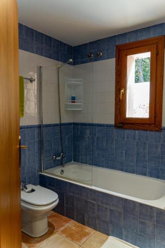 a blue tiled bathroom with a tub and a toilet at VILLA SOFIA in Valldemossa