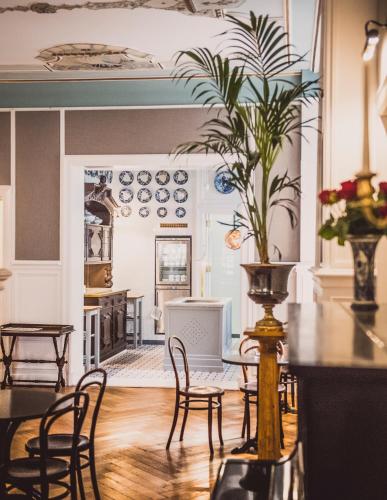 a dining room with chairs and a table with a potted plant at HENRI Hotel Berlin Kurfürstendamm in Berlin