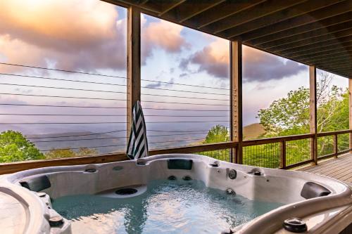 a bath tub in a room with a large window at Above and Beyond in Boone