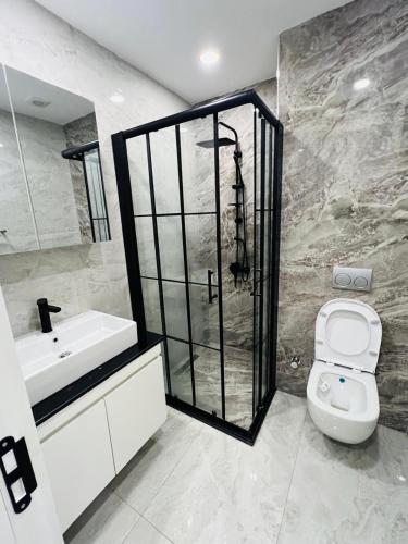 a bathroom with a shower and a toilet and a sink at Wanderlust Executive Stay in Maputo
