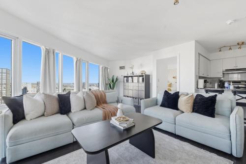 a living room with a couch and a table at Stylish 2BR Downtown Escape Prime Victoria Spot in Toronto