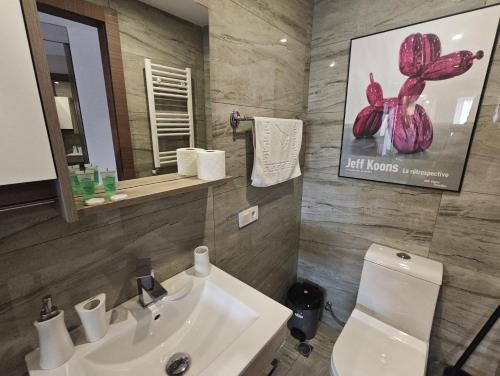 a bathroom with a sink and a toilet and a mirror at New Gudauri GoodHost Apartments in Gudauri