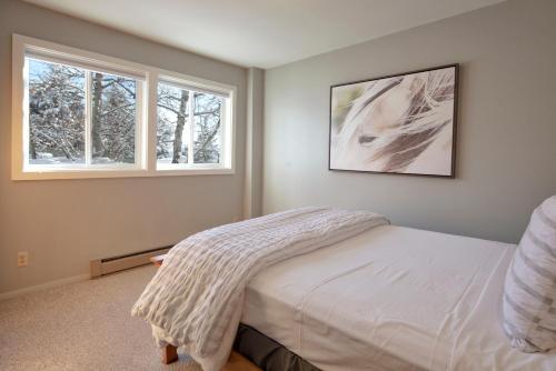 a bedroom with a bed and two windows at The Way Home at Tensleep North in Teton Village