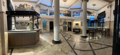 a lobby with a bar and tables in a building at Atlântico Hotel in Santos