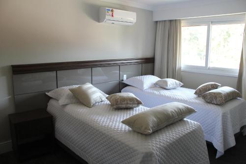 two beds in a hotel room with pillows on them at Hotel Gramado Interlaken in Gramado