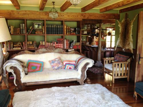 a living room with a couch and bookshelves at Barraco Lodge in Puelo