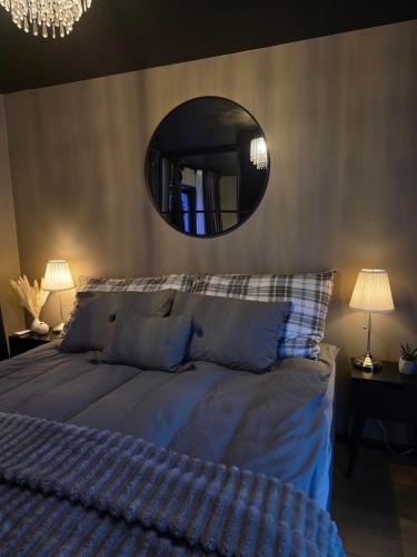 a bedroom with a bed with a mirror above it at Aurora View Apartment - Free Parking & Walkable City Location in Tromsø