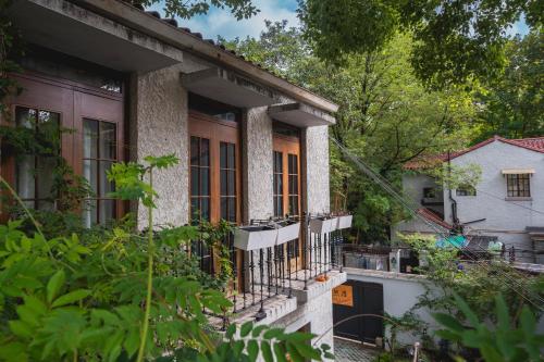 an old house with windows and a balcony at Tonight Homestay South Shanxi Road Shanghai in Shanghai