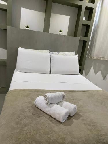 a bed with two rolled towels on it at Amoras flat in Sao Jorge