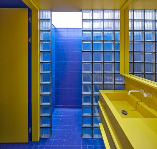 un bagno con un lavandino giallo e piastrelle blu di Pop Haus Vilnius a Vilnius
