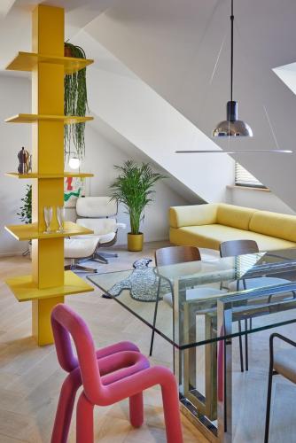 un soggiorno con sedie colorate e un tavolo di vetro di Pop Haus Vilnius a Vilnius