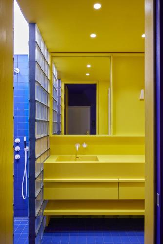 un bagno giallo con un lavandino e uno specchio di Pop Haus Vilnius a Vilnius
