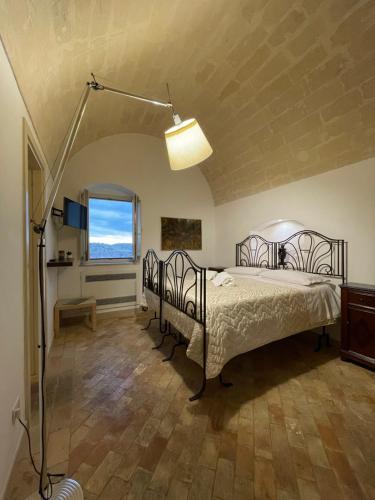 a bedroom with a bed and a lamp in a room at Dimora La Gravina in Matera