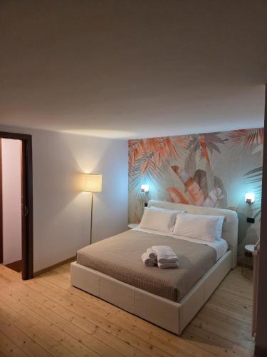 a bedroom with a bed with a painting on the wall at La Dimora di Vittorio Emanuele II in Barletta