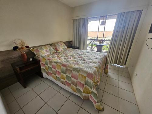 a bedroom with a bed with a table and a window at FLATS MONTE CASTELO GRAVATÁ CONDOMÍNIO MELHOR LOCALIZAÇÃo in Gravatá