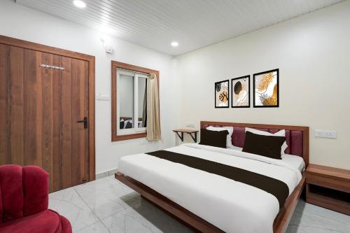 a bedroom with a large bed and a red chair at Hotel O Royal Krishna in Gorakhpur