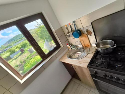 Una cocina con fregadero, estufa y ventana. en Holiday home with vineyard and city view, 
