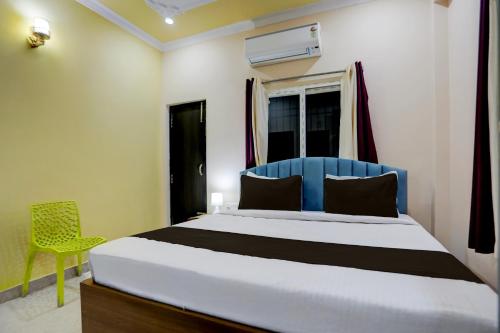 Un dormitorio con una cama con cabecero azul y una ventana. en Hotel O kumar inn, en Lok Nayak Jayaprakash Airport