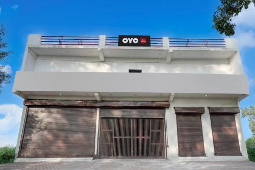 a white building with a qo sign on top of it at Hotel O Choudhary Hotel and Resort in Anūpnagar