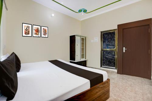a bedroom with a bed and a wooden door at Hotel O Kanha Paying Guest House in Varanasi