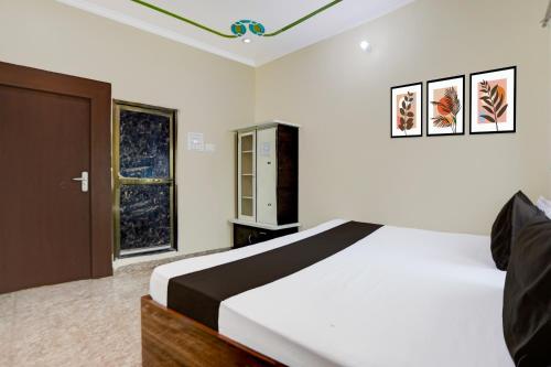 a bedroom with a large bed and a window at Hotel O Kanha Paying Guest House in Varanasi