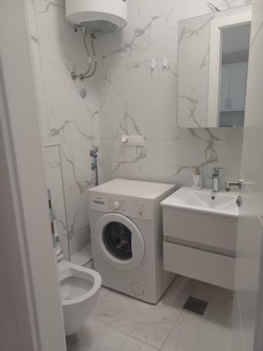 Un baño con lavadora y lavabo. en Apart Mostar, en Mostar