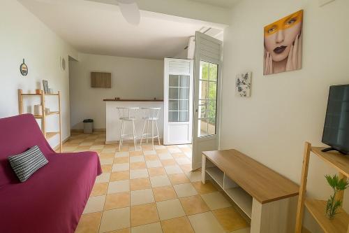 een woonkamer met een bank en een tafel bij T2 Tropical avec terrasse et jardin in La Trinité