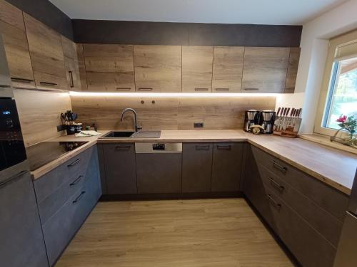 a kitchen with wooden cabinets and a sink at Appartement Catrin mit Sauna und E-Ladestation in Ried im Zillertal