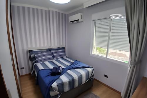 a bedroom with a bed and a window at SHB - Apto Aconchegante Família Moderno in Santos