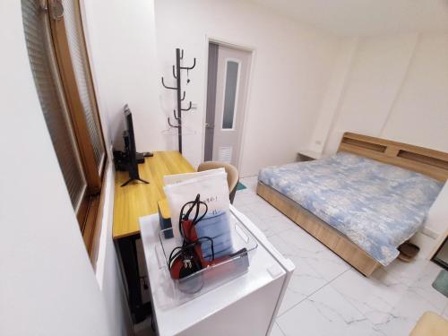 Cette petite chambre comprend un lit et une table avec un bureau. dans l'établissement Mishi B&B, à Tamsui