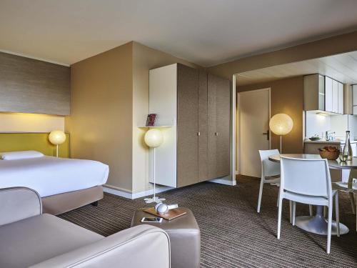 a hotel room with a bed and a table at AppartHotel Mercure Paris Boulogne in Boulogne-Billancourt