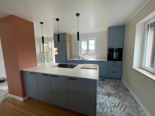 a kitchen with blue cabinets and a white counter top at Le Kintz' in Kintzheim