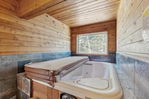 a large tub in a wooden bathroom with a window at Beaverhead 1421 in Big Sky