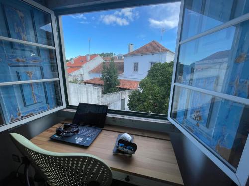 a laptop computer sitting on a desk in a window at Orange Tree house, Silver Coast, Alcobaça, Nazaré in Alpedriz