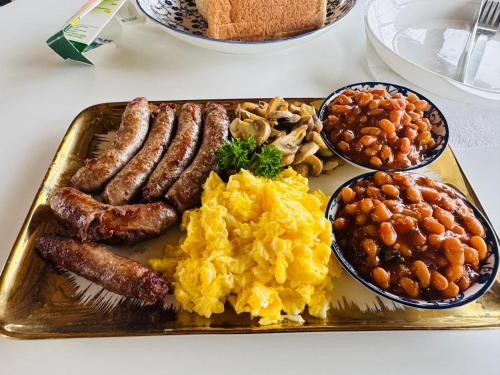 a plate of breakfast food with eggs sausage and beans at Ocean Crest Lodge in Zinkwazi Beach